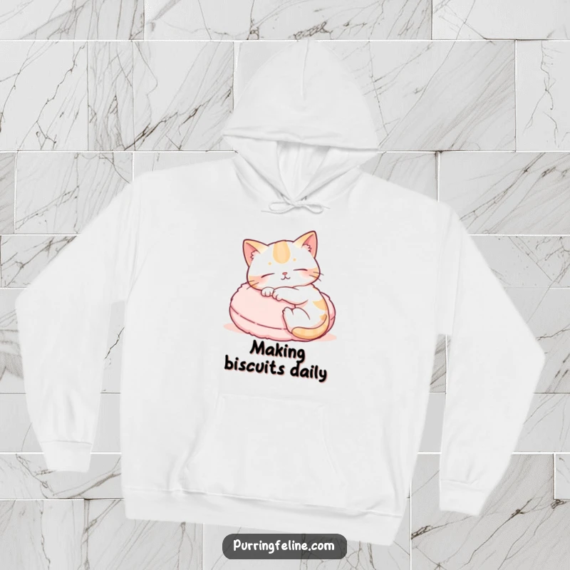 Funny hoodie featuring a content cat rhythmically kneading a fluffy cushion, evoking a sense of warmth and tranquil bliss.